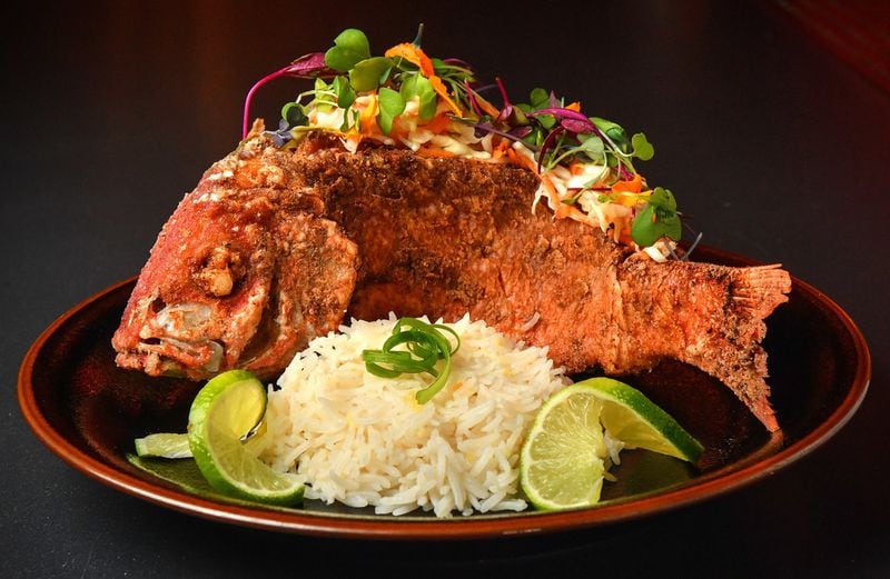Rock Steady Haitian Fried Snapper, shown here with coconut rice, might be the most popular item on the restaurant’s menu. If you’re making it at home, it is possible to re-create the swimming fish look. STYLING BY CHRISTIAN LUCKE BELL / CONTRIBUTED BY CHRIS HUNT PHOTOGRAPHY