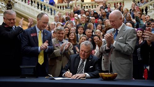 April 16, 2015 Atlanta, GA: Gov. Nathan Deal signs House Bill 1 Thursday amid a crowd of supporters. The bill now allows the limited use of cannabis oil to treat disorders that include cancer, sickle cell disease and epilepsy as long as a physician signs off. BRANT SANDERLIN/BSANDERLIN@AJC.COM Gov. Nathan Deal signs House Bill 1 Thursday amid a crowd of supporters. BRANT SANDERLIN/BSANDERLIN@AJC.COM