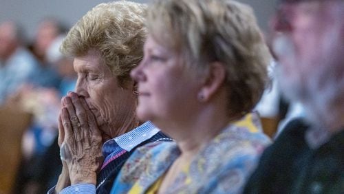A woman prays in the courtroom at the start of the hearing against the North Ga Conference of the United Methodist Church in Marietta Tuesday, May 16, 2023.   (Steve Schaefer/steve.schaefer@ajc.com)
