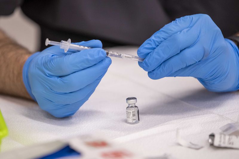 File photo of a COVID-19 vaccination being placed in a syringe. (Alyssa Pointer / Alyssa.Pointer@ajc.com)