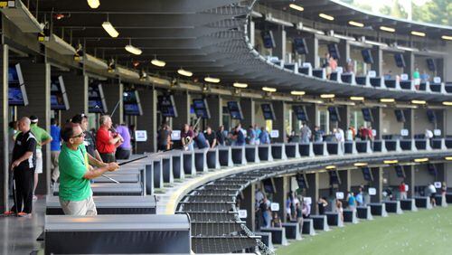 Customers at hitting bays at TopGolf Alpharetta in this AJC file photo.