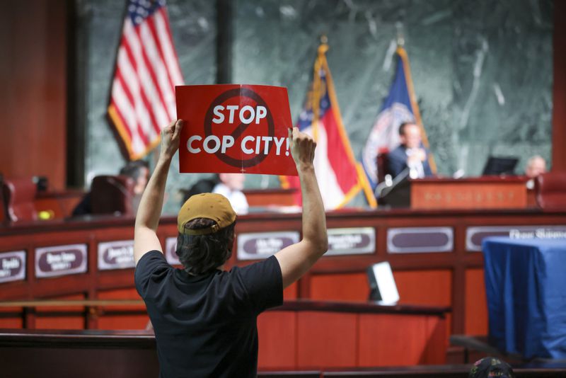 A protestor holds a “Stop Cop City,” sign to the Atlanta City Council during the public comment portion ahead of the final vote to approve legislation to fund the training center at Atlanta City Hall, on Monday, June 5, 2023, in Atlanta. (Jason Getz / Jason.Getz@ajc.com)