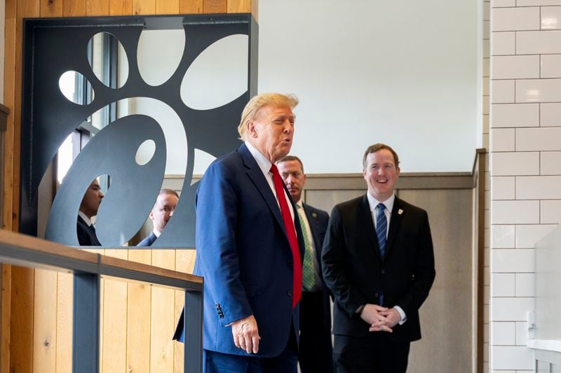 Former President Donald Trump (left) is accompanied by Brian Jack (right) at a Chick-fil-A in Atlanta on Wednesday.