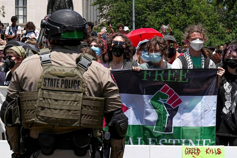 Pro-Palestinian protesters stand with linked arms surrounded by Texas state troopers and police at an encampment at University of Texas in Austin, Texas, Monday, April 29, 2024. (Aaron E. Martinez/Austin American-Statesman via AP)