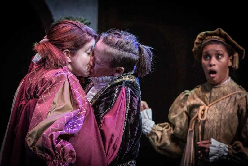 Antonio (Mary Ruth Ralston, center) passionately embraces his friend Bassanio (Kelly Criss, left) during a trial in which Antonio’s life hangs in the balance. Gratiano (Cameryn Richardson, right) reacts.
