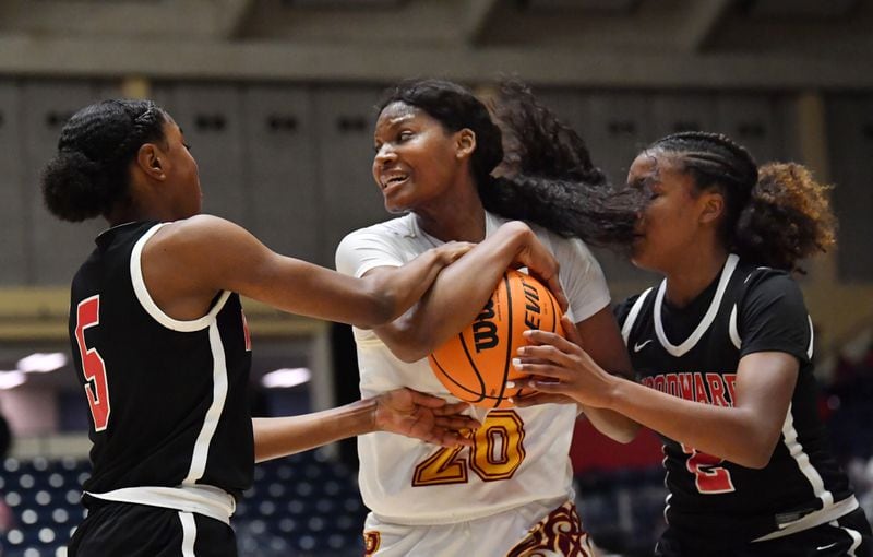 Forest Park's Sania Feagin (20) holds onto the ball as Woodward Academy's Savannah Simms (5) and Sara Lewis (2) attempt a steal during the Class 5A girls championship game Thursday, March 11, 2021, in Macon. (Hyosub Shin / Hyosub.Shin@ajc.com)