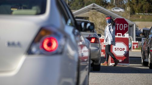 Workers walked up and down a line of cars to gather individuals personal information before they proceeded to take a COVID19 test at a DeKalb County Department of Health COVID-19 drive-thru testing site in Doraville, Tuesday, Nov. 17, 2020.  (Alyssa Pointer / Alyssa.Pointer@ajc.com)