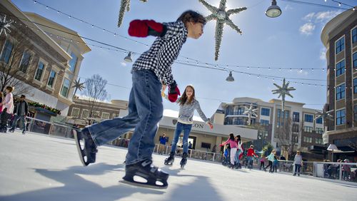 Alex Coney (left) and Abby Ostwald skate on the ice rink at Avalon in Alpharetta on Nov. 30, 2014. The rink will be open most days through February 2015. JONATHAN PHILLIPS / SPECIAL
