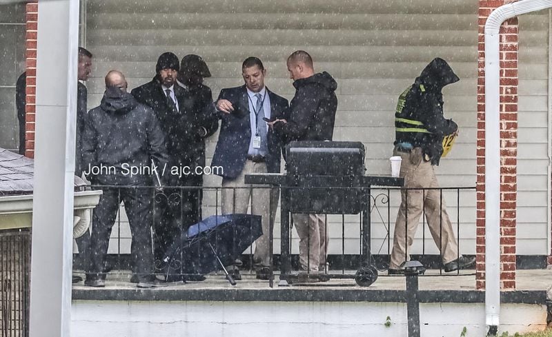 Atlanta police officers and GBI agents investigate in the rain after a woman was shot by police in the 2800  block of Eleanor Terrace.