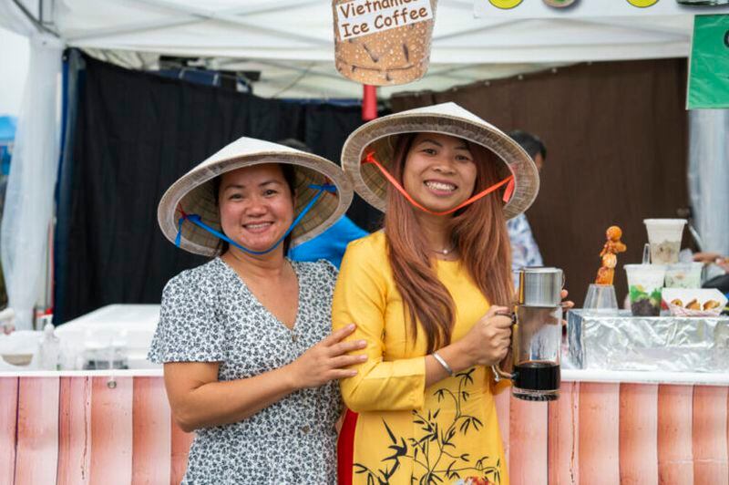 Sofia Le (left), owner of Chè (Quán Cô Sáu), poses with her best friend, Cam Le in front of their tent in Lawrenceville, Georgia, Sept. 10, 2022. Sofia does not have her own shop, but night markets like “Around in the World in the DTL” allow her to gain experience in having a business. (Kendra A. Ransum/Fresh Take Georgia)