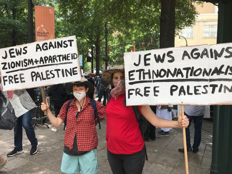 Katz Tepper (left) and Mo Costello carried signs to emphasize that many Jews, including themselves, sympathize with the plight of the Palestinians. Bo Emerson/bemerson@ajc.com