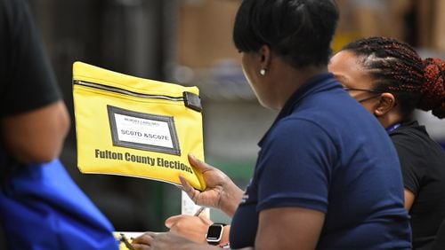 An election worker checks memory card bag contained votes at Fulton County Election Preparation Center on Tuesday, May 24, 2022. (Hyosub Shin / Hyosub.Shin@ajc.com)