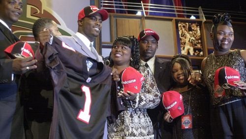 Quarterback Michael Vick, second from left, of Virginia Tech, holds up an Atlanta Falcons jersey after being selected as the No. 1 overall pick of the NFL draft in New York, Saturday, April 21, 2001 in New York. Vick is joined by his mother, Brenda Boddie, center, and unidentified members of his family. (AP Photo/Ed Betz)