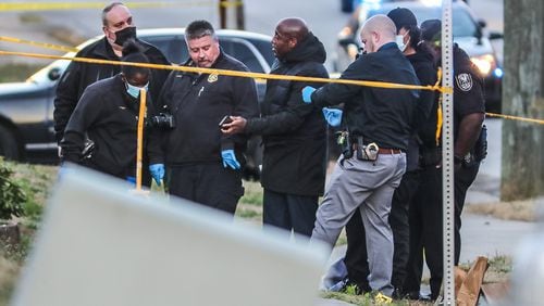 Investigators gather evidence after a man's body was found on a sidewalk Wednesday morning outside a strip mall on Glenwood Road. He had been shot, according to DeKalb County police.