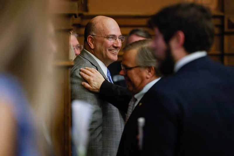Rep. Todd Jones (R-South Forsyth) smiles as House members congratulate him on the passage of HB 520 on day 27 of the legislative session on Thursday, March 2,  2023. (Natrice Miller/ Natrice.miller@ajc.com)