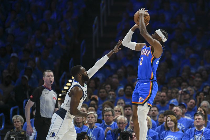 Oklahoma City Thunder guard Shai Gilgeous-Alexander, right, shoots against Dallas Mavericks forward Tim Hardaway Jr. during the first half in Game 2 of an NBA basketball second-round playoff series, Thursday, May 9, 2024, in Oklahoma City. (AP Photo/Kyle Phillips)