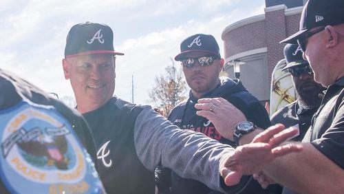 Braves manager Brian Snitker (left) and first baseman Freddie Freeman (center) greet fans before the start of the home opener Monday, April 1, 2019, against the Chicago Cubs at SuntTrust Park in Atlanta.