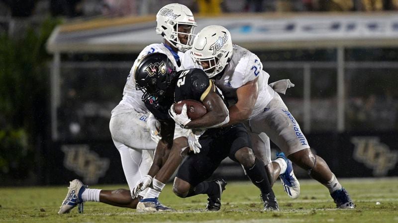 Central Florida running back Johnny Richardson (25) is tackled by Tulsa linebacker Zaven Collins (23) after rushing for yardage during the second half Saturday, Oct. 3, 2020, in Orlando, Fla. (Phelan M. Ebenhack/AP)