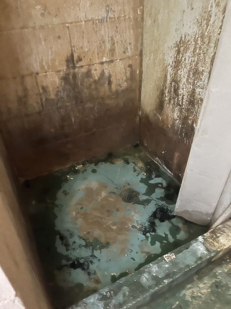 A shower stall shows mold and discoloration in this image from Georgia Legal Services Program staff.