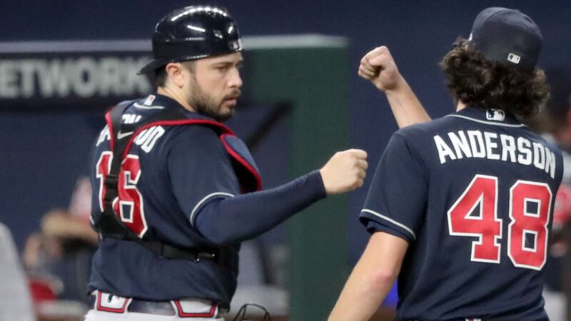 Braves catcher Travis d'Arnaud, left, first bumps starting pitcher Ian Anderson (48) after ending the second inning against the Los Angeles Dodgers in Game 7 of the NLCS Sunday, Oct. 18, 2020, at Globe Life Field in Arlington, Texas. (Curtis Compton / Curtis.Compton@ajc.com)



