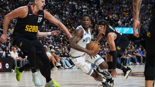 Minnesota Timberwolves guard Anthony Edwards, center, drives to the basket between Denver Nuggets center Nikola Jokic, left, and forward Aaron Gordon in the second half of Game 7 of an NBA second-round playoff series Sunday, May 19, 2024, in Denver. (AP Photo/David Zalubowski)