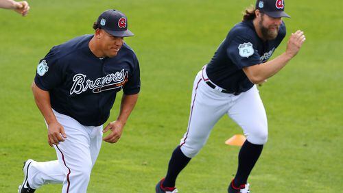 Pitchers Bartolo Colon (left) and R.A. Dickey run “sprints” side by side during their first spring training workout as Braves. (Curtis Compton/ccompton@ajc.com)