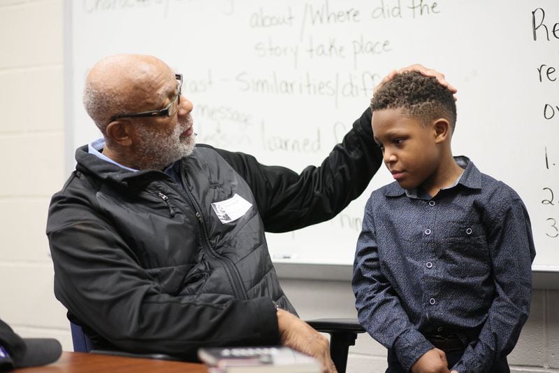 Before John Carlos began his presentation, he shared the spotlight with second-grade student Jeremiah Green, 8, who made a presentation about Carlos’s story at Barack H. Obama Elementary Magnet School of Technology on Wednesday, Feb. 26, 2020 in Atlanta. Jeremiah’s grandfather grew up with John Carlos in Harlem, N.Y. (Photo: MIGUEL MARTINEZ for the AJC)