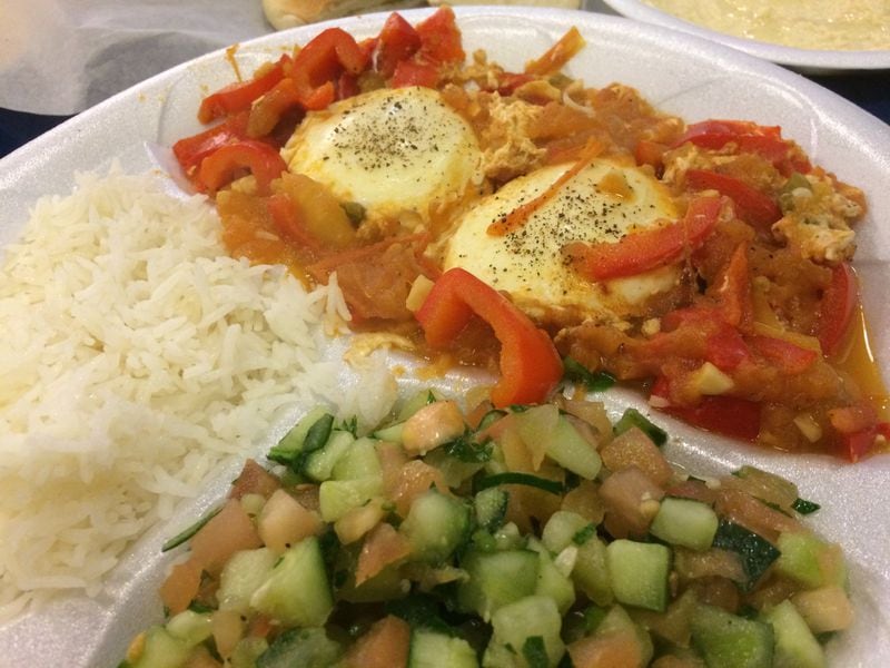 Shakshuka (poached eggs in a sauce of tomatoes, peppers and onions) with rice and salad at kosher restaurant Pita Grille. LIGAYA FIGUERAS / LFIGUERAS@AJC.COM