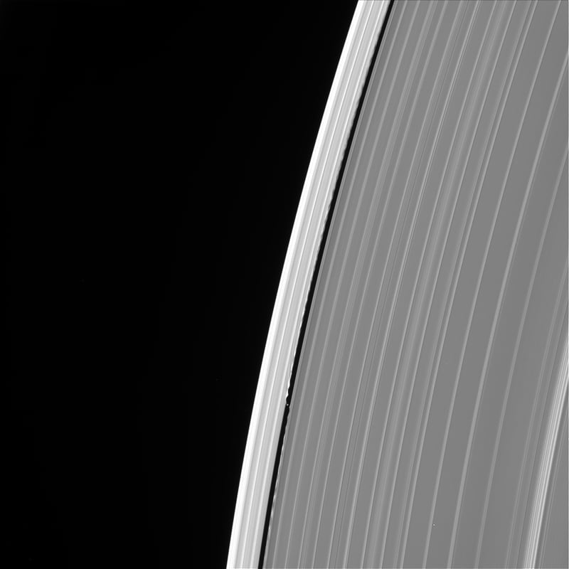 Image of Saturn's outer A ring featuring the small moon Daphnis and the waves it raises in the edges of the Keeler Gap.