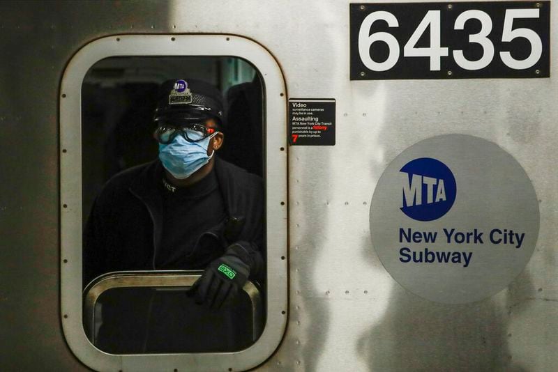 FILE - In this April 7, 2020, file photo, an MTA worker wears personal protective equipment at the Grand Army Plaza station in the Brooklyn borough of New York. As the coronavirus tightened its grip across the country, it is cutting a particularly devastating swath through an already vulnerable population, black Americans. (AP Photo/Frank Franklin II, File)