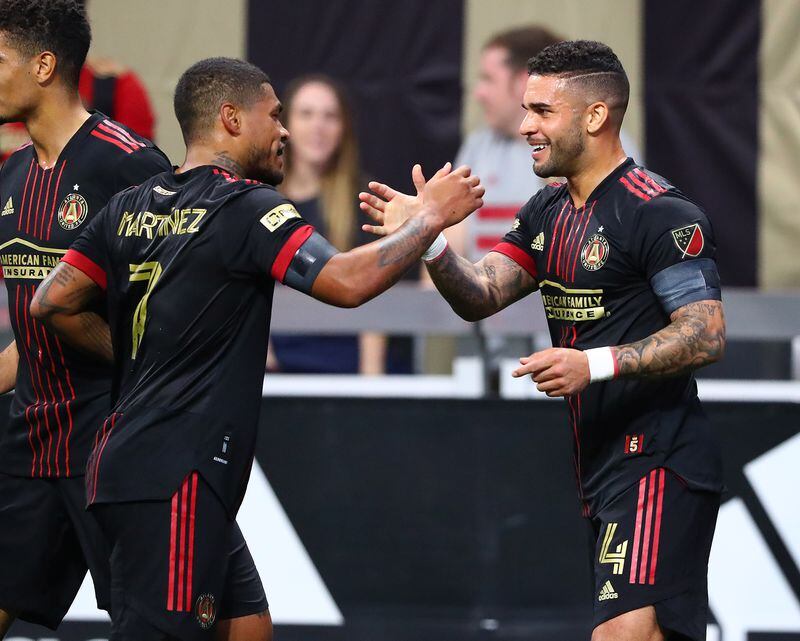 Atlanta United's Dom Dwyer (right) gets five from fellow attacker Josef Martinez after scoring a goal for a 2-0 lead over Sporting KC in an MLS soccer match Sunday in Atlanta. (Curtis Compton / Curtis.Compton@ajc.com)`