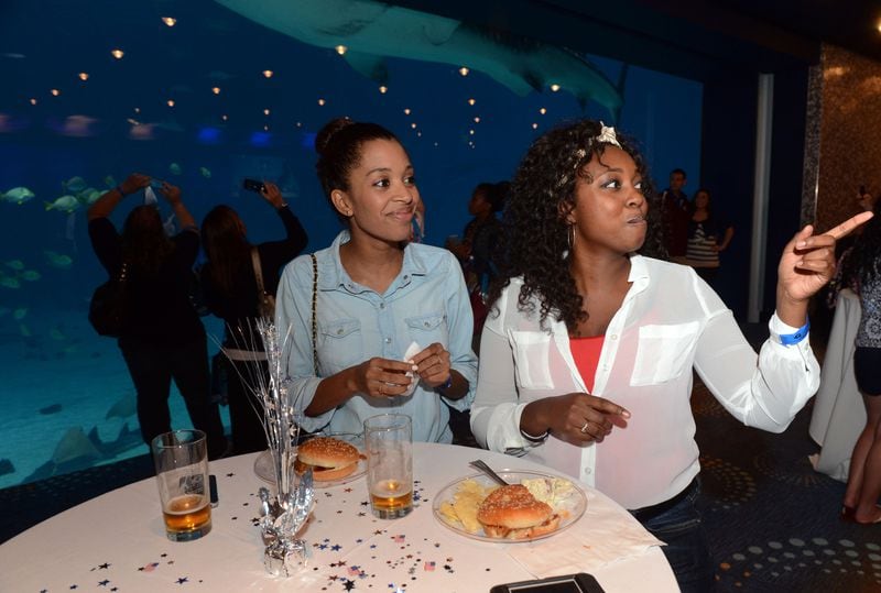 Nicole Anderson (left) of Atlanta and Loryn Wellman of Kennesaw, watch the band during the Georgia Aquarium's Red White and Brew event Thursday, July 4, 2013.