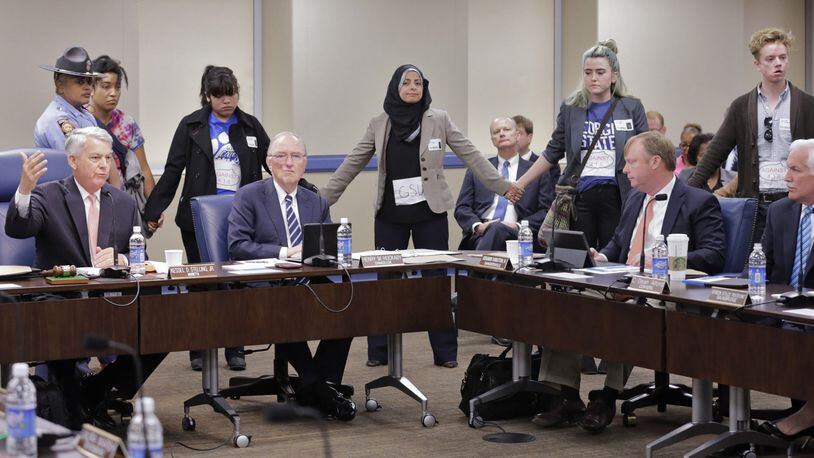 November 9, 2016 - Atlanta - After giving the protestors a few minutes, Regents Chair Kessel Stelling, Jr. (left), asks them to take their seats. Immigrant rights activists and faith leaders protested Georgia Board of Regents policies that bar immigrants without legal status from attending five of the state’s top schools and paying in-state tuition rates at its others. The protest was planned by Freedom University, a tuition-free school for immigrants without legal status. BOB ANDRES /BANDRES@AJC.COM