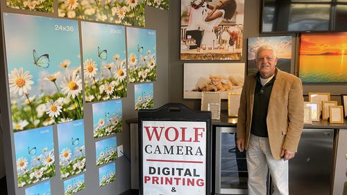 The namesake of Chuck Wolf's Photo Design Bar stands inside inside the entrance of his lone store in Buckhead. Wolf once reigned over an empire of 700-plus photo shops before the business changed.