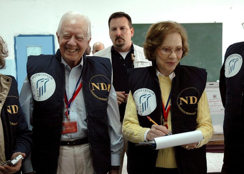 In this image released by the Carter Center, former U.S. President Jimmy Carter, left, and his wife Rosalyn smile as they visit a polling station during the Palestinian parliamentary elections in Arab east Jerusalem Wednesday Jan. 25, 2006. Nearly 20,000 local observers and 950 international monitors, led by Carter, watched the vote. (AP Photo/Deborah Hakes, The Carter Center)