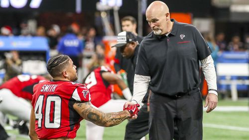 Atlanta Falcons head coach Dan Quinn speaks with running back Keith Smith (40) before the start of final home game Sunday, Dec. 22, 2019, against the Jacksonville Jaguars at Mercedes-Benz Stadium in Atlanta.