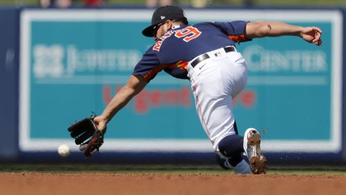 Houston Astros shortstop Jack Mayfield dives for a ground ball single by New York Mets' Michael Conforto during the third inning of a spring training baseball game Saturday, Feb. 29, 2020, in West Palm Beach, Fla. (Jeff Roberson/AP)
