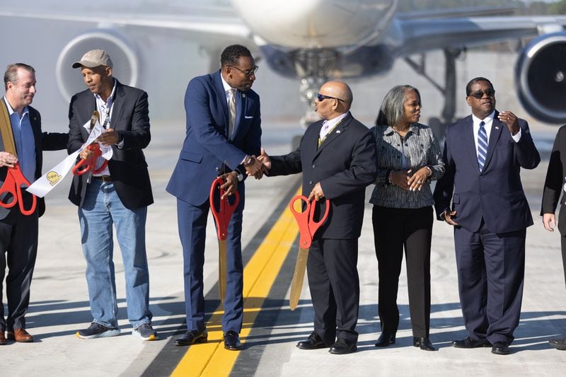 Mayor Andre Dickens and Airport General Manager Balram “B” Bheodari  shake hands after a ribbon cutting for a new Taxiway Improvement at Hartsfield-Jackson Atlanta International Airport Tuesday, Nov. 1, 2022. (Steve Schaefer/steve.schaefer@ajc.com)