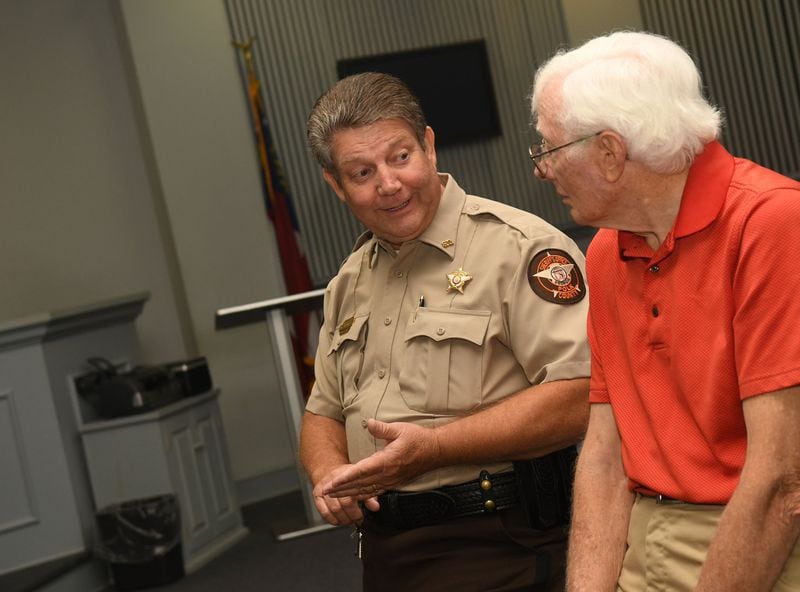 Deputy Mike Sullivan (left) and Frank Lott Jr. (right) talk about Polk County Sheriff Frank Lott’s murder in Cedartown, Ga., on August 18, 2017. Forty-three years after Frank Lott was shot and killed as he investigated a reported burglary at the local high school, no one has been convicted. There was a suspect who went to trial but a jury acquitted him. Some say Lott’s successor damaged the case by refusing to share information with other agencies investigating the shooting. (Rebecca Breyer)