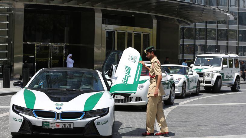 In this Thursday May 19, 2016 photo, Dubai police Lt. Saif Sultan Rashed al-Shamsi, who oversees the tourist police’s patrol section, pushes down one of the twin scissor doors of the $140,000 BMW i8 during a demonstration in Dubai, United Arab Emirate. Police in Dubai have built up a high-horsepower arsenal of luxury sports cars and SUVs over the years to complement its fleet of green-and-white patrol cruisers. They say it is a way to reach out to the community and make their officers more accessible to the public in a country home to huge foreign workforce. (AP Photo/Kamran Jebreili)