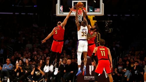 LOS ANGELES, CALIFORNIA - NOVEMBER 17:  Dwight Howard #39 of the Los Angeles Lakers goes up to dunk as he's guarded by Jabari Parker #5 and DeAndre' Bembry #95 of the Atlanta Hawks during the first half of a game at Staples Center on November 17, 2019 in Los Angeles, California. NOTE TO USER: User expressly acknowledges and agrees that, by downloading and or using this photograph, User is consenting to the terms and conditions of the Getty Images License Agreement. (Photo by Katharine Lotze/Getty Images)