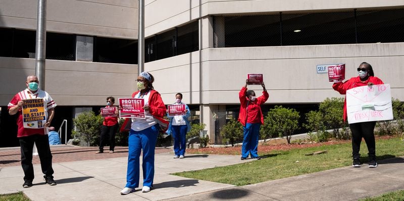 In a protest organized by the National Nurses United union, a group of nurses and their supporters held up signs for passing cars outside of the Atlanta VA Medical Center on Friday. One sign said, “Say no to 1 mask/week.” Ben@BenGray.com for the Atlanta Journal-Constitution