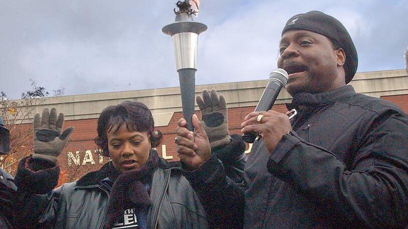 Bishop Eddie Long (right) and Bernice King pray December 11, 2004 after passing the torch at the start of a march against gay marriage and other issues. AJC FILE PHOTO