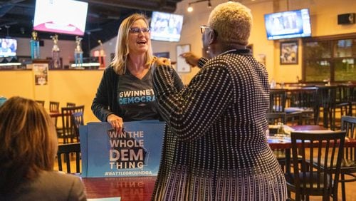 111419 NORCROSSâ€” From left, Penny Bernath, Chair of Campaign Elections, greets Pinkie Farver, the District Director for the Georgia Federation of Democratic Women before they watch the presidential debates held in Atlanta Wednesday, November 20, 2019 at Mazzyâ€™s Sports Bar in Norcross, Ga. PHOTO BY ELISSA BENZIE