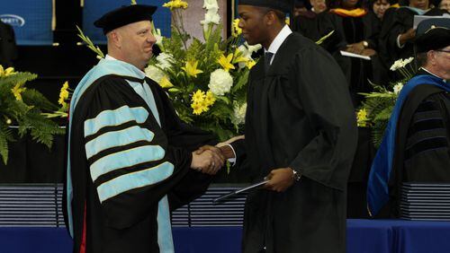 Gwinnett Technical College President Glen Cannon (left) congratulates a student at a 2015 commencement ceremony. AJC FILE PHOTO