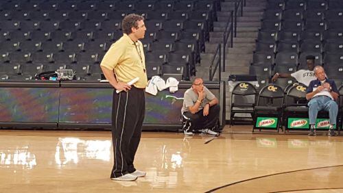 Ron Bell, kneeling in the background, watches Georgia Tech’s basketball team practice in 2016. Bell, a reformed prescription-drug addict and former prison inmate, befriended coach Josh Pastner, standing in the foreground, gaining remarkable access to Pastner’s teams and his family. Then their relationship dissolved amid allegations of NCAA violations, blackmail and sexual assault. Photo courtesy of Ron Bell.