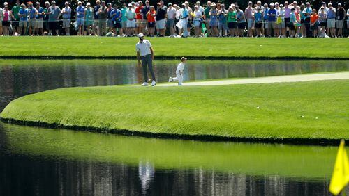 Dustin Johnson and son, Tatum, stand on the ninth green during the par-3 golf tournament at the 2019 Masters Tournament at Augusta National Golf Club. The Par 3 Contest is out at the spectator-free Masters in November.