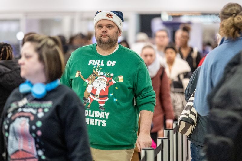 Terry Mitchell makes his way through security at Hartsfield-Jackson Atlanta International Airport on Friday, which is expected to be the peak day for Christmas holiday travel  (Steve Schaefer/steve.schaefer@ajc.com)