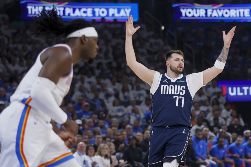 Dallas Mavericks guard Luka Doncic, right, reacts as Oklahoma City Thunder guard Shai Gilgeous-Alexander looks on during the first half of Game 1 of an NBA basketball second-round playoff series, Tuesday, May 7, 2024, in Oklahoma City. (AP Photo/Nate Billings)