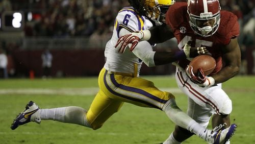 LSU safety Craig Loston tries to bring down Alabama’s Jalston Fowler in the Crimson Tide’s victory on Nov. 9. Loston, one of three LSU defensive starters from Texas, and his teammates will host Texas A&M on Saturday. CREDIT: Dave Martin/AP Photo